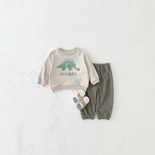 Children's outfit with beige sweatshirt and gray pants featuring a stegosaurus design on a white background.